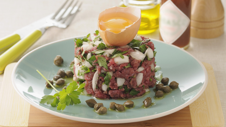 steak tartare dish on blue plate with egg