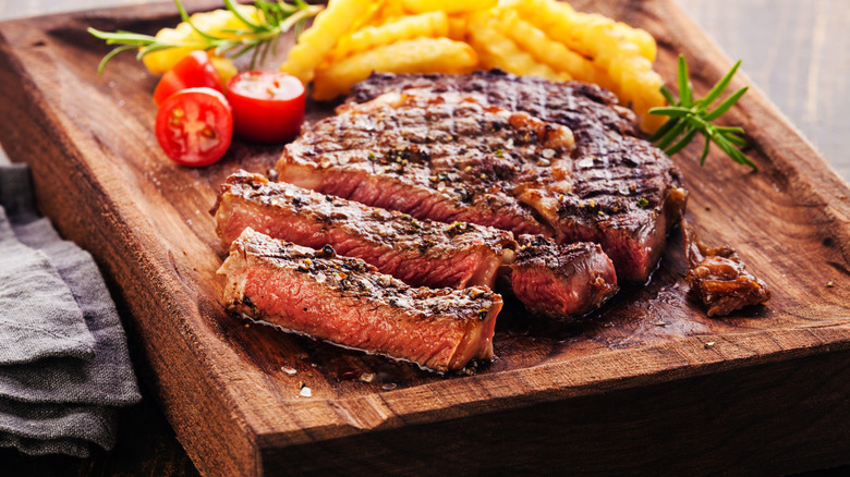 sliced ribeye steak on a cutting board