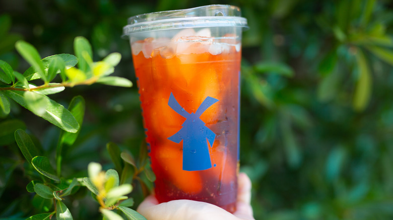 Dutch Bros sparkling soda surrounded by leaves