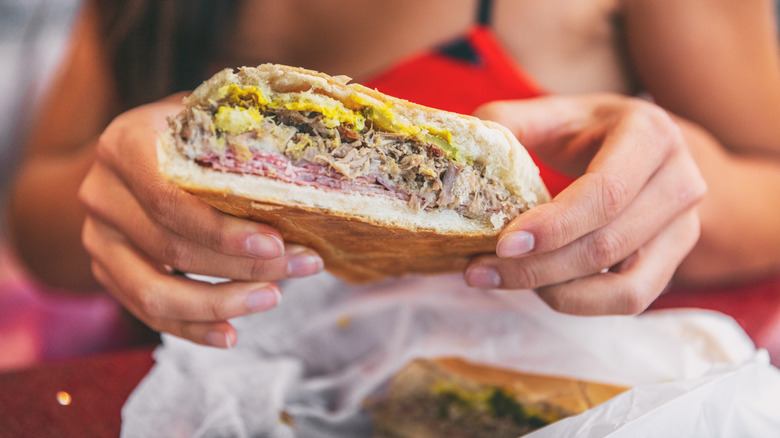 hands holding cuban sandwich