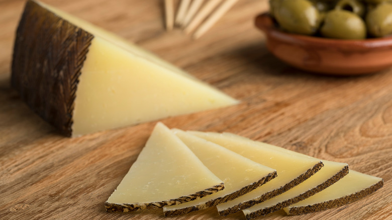 Slices of manchego cheese on cutting board