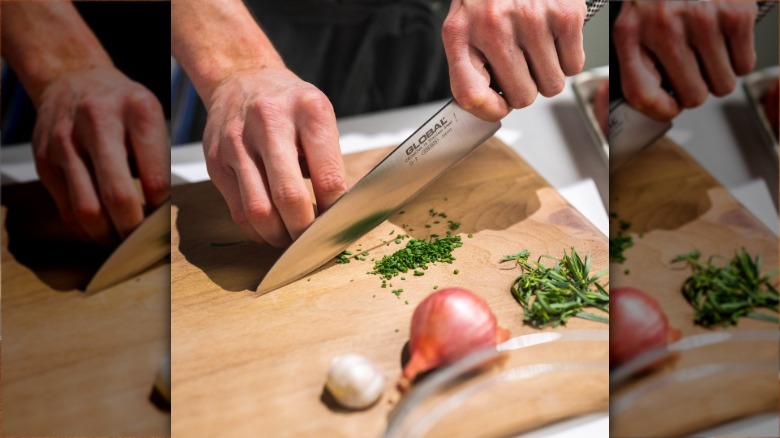 Person chopping chives with a Global chef's knife