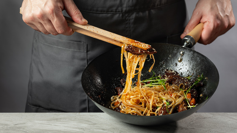 Asian stir fry being prepared in a wok
