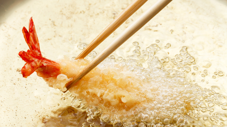 cooking tempura shrimp with chopsticks  