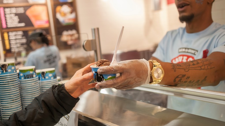 worker serving cup of Ben & Jerry's 