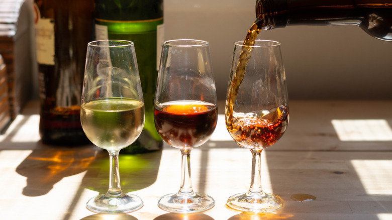 A person prepares a flight for sherry tasting.