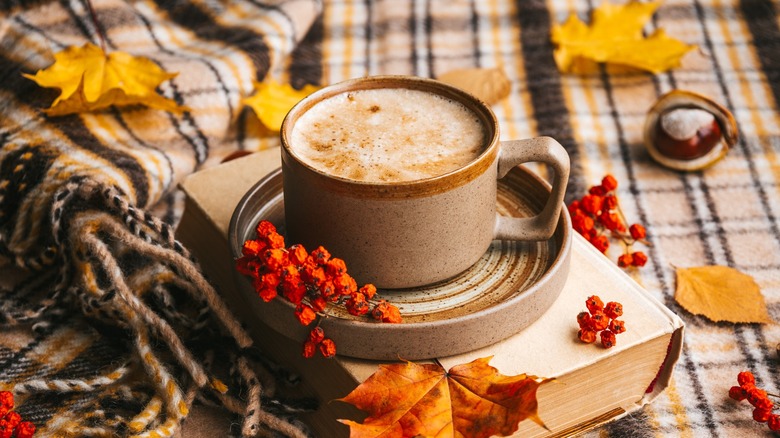 Mug of coffee with autumn leaves