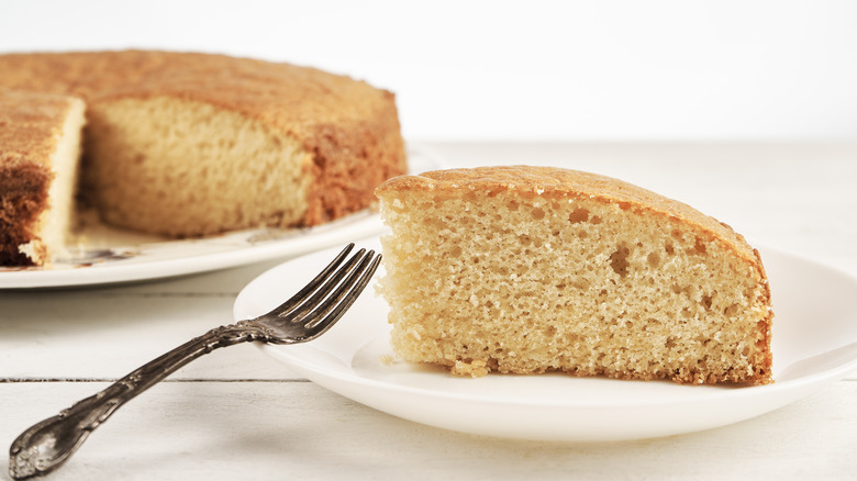 Slice of sponge cake on plate with fork