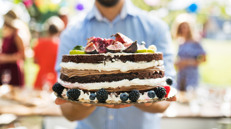 man holding cake at party