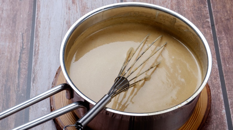 Pot of gravy with whisk