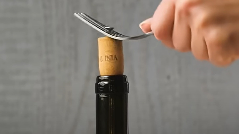 Opening wine bottle with screw and fork