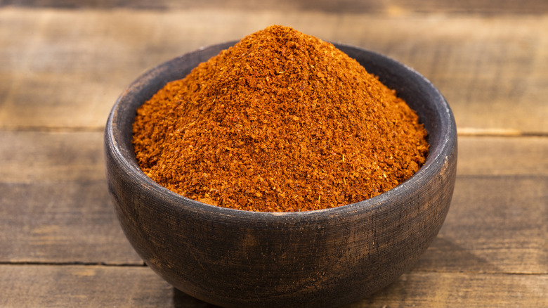 paprika poured in wooden bowl