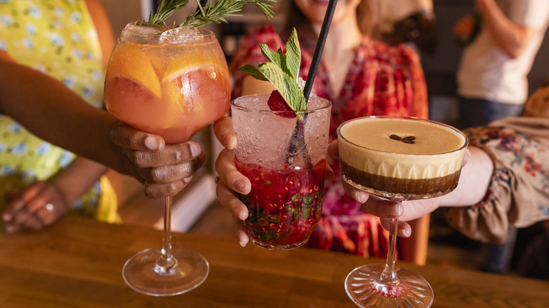 toasting cocktails at a busy bar