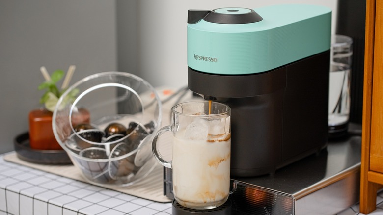 A Nespresso machine, container of pods, and iced coffee