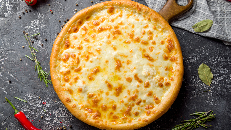 Cheese pizza on wooden paddle