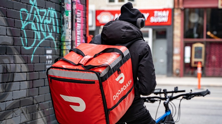 A DoorDash delivery person on a bike