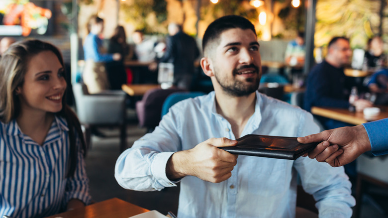 man paying bill at restaurant