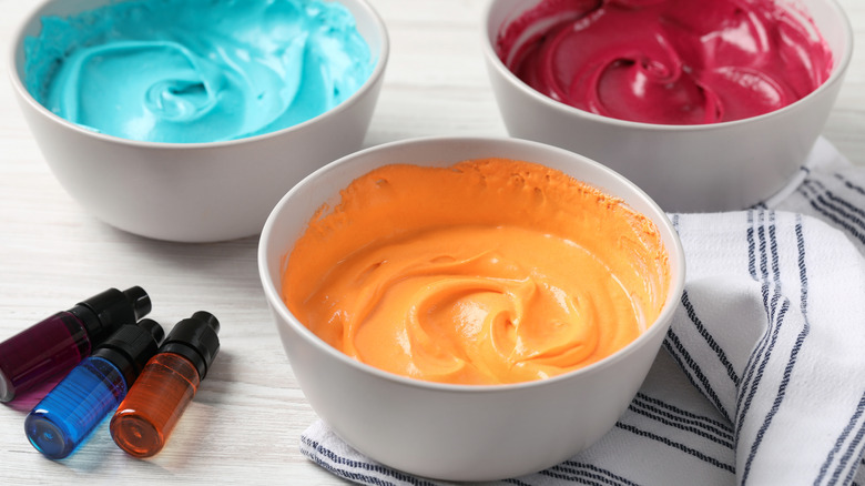 Bowls of colored frosting with food dyes