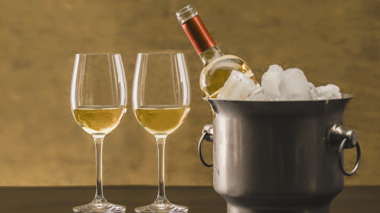 Chilled wine in bucket next to glasses