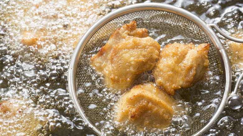 Frying chicken pieces in skimmer