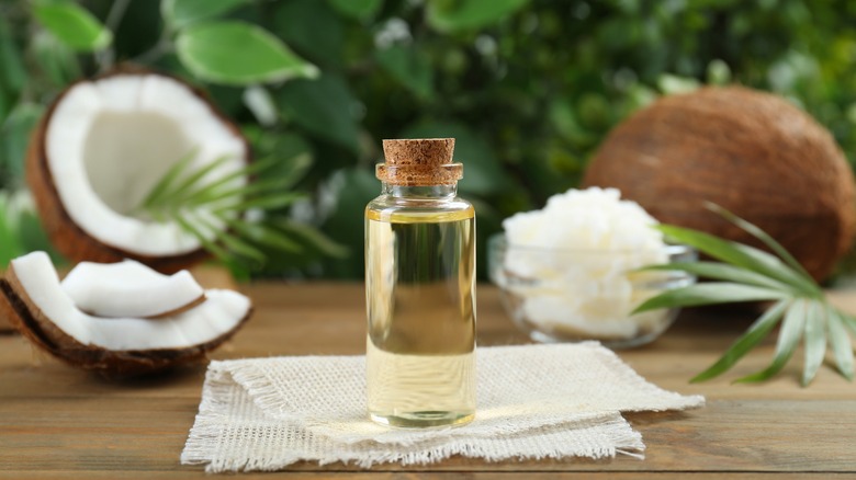 Coconut oil on table with coconuts