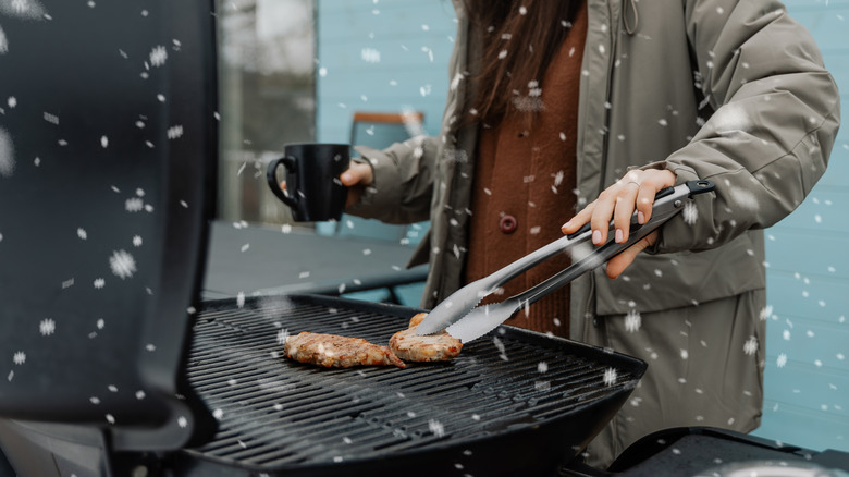 person grilling in snow outdoors