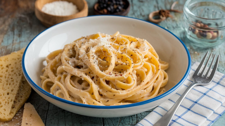 a bowl of cacio e pepe with a fork on a napkin