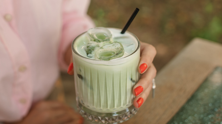 Person holding iced matcha latte