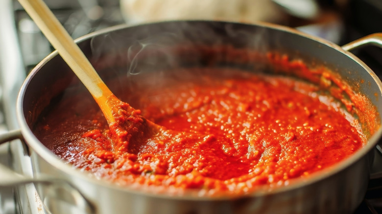 Pot cooking red sauce steaming