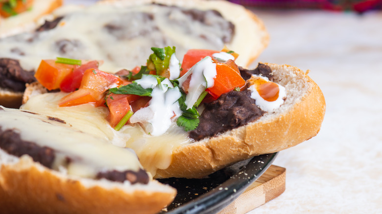 pan telera with refried black beans, melted cheese adn pico de gallo