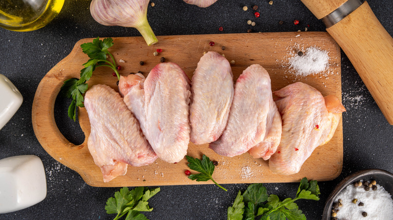 Raw chicken wings surrounded by cooking ingredients