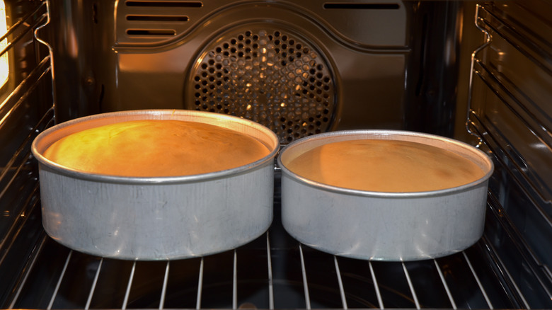 two cakes baking in oven