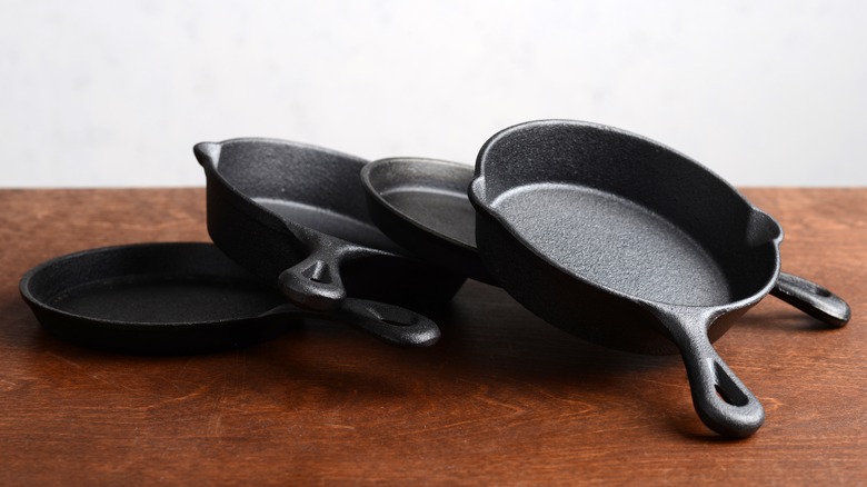 pile of cast iron pans on table