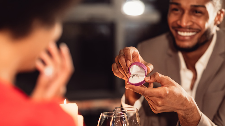 smiling man holding ring box 