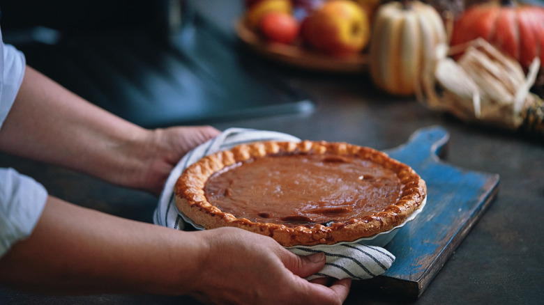 baker carrying pumpkin pie