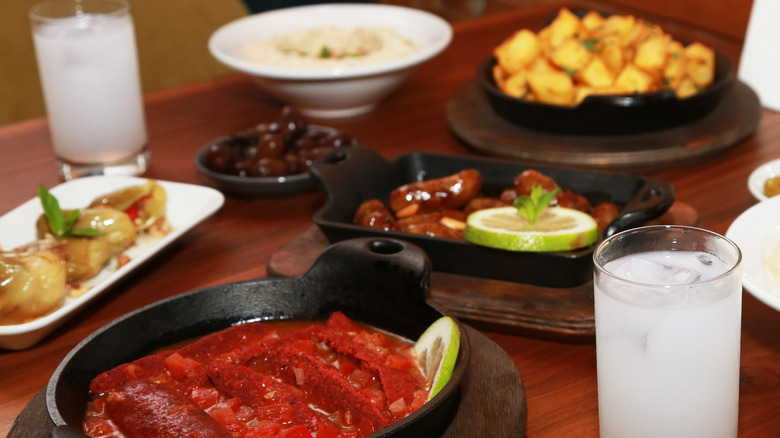 traditional Lebanese meal with glasses of Arak on wood table