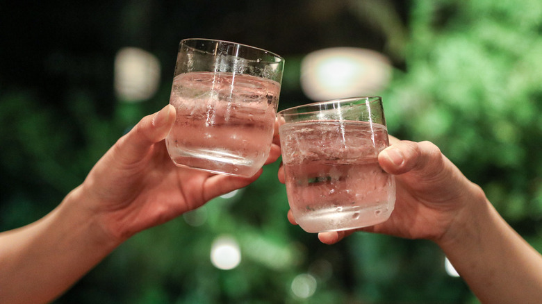 two shochu glasses in hands