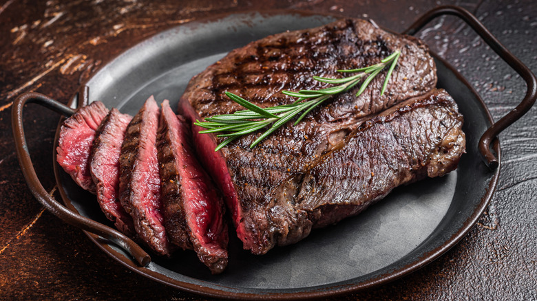 Sliced rare cooked lean steak in pan