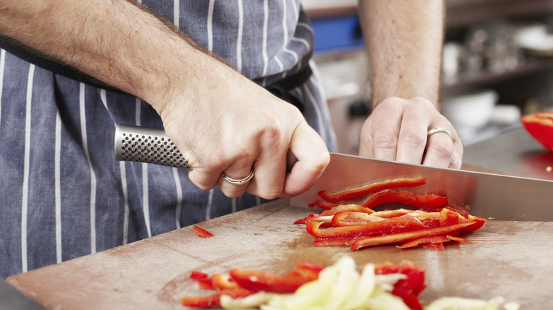 man slicing peppers