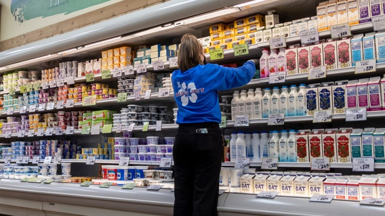 Trader Joe's employee stocking milk fridge