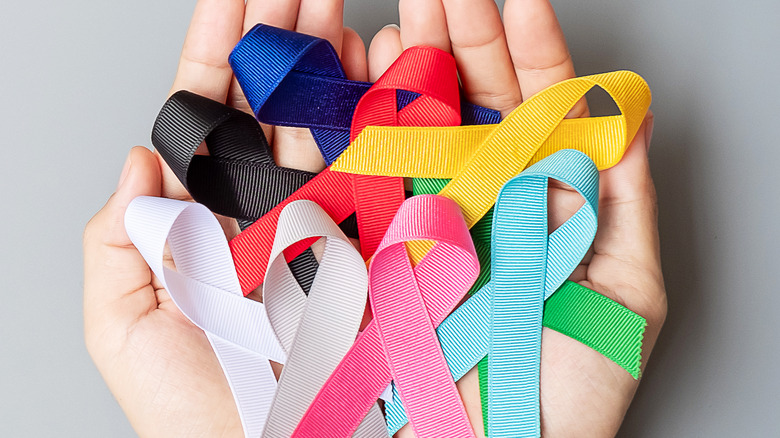 Hands holding ribbons representing cancer