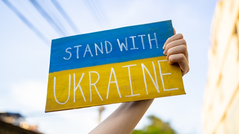 protestor's "Stand with Ukraine" sign