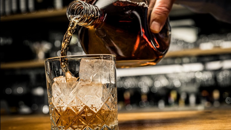 Whiskey being poured from a bottle into a glass 