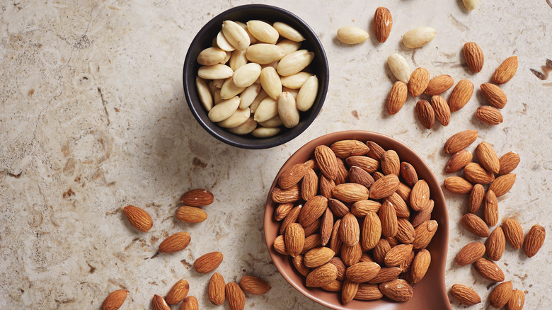 Raw and blanched almonds in bowls