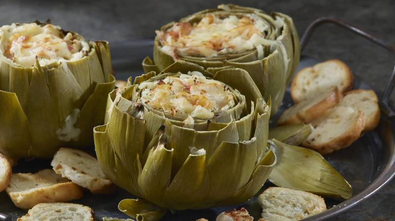 Close-up of three artichokes stuffed with a cheesy mixture