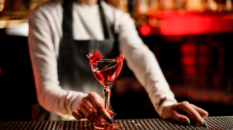 Bartender handing Campari cocktail