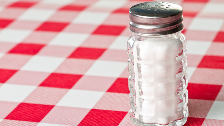 Salt shaker on checkered tablecloth 