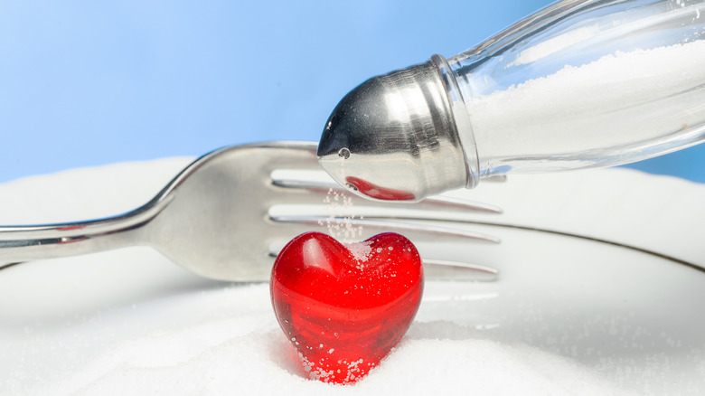 Fork and salt shaker posed over heart