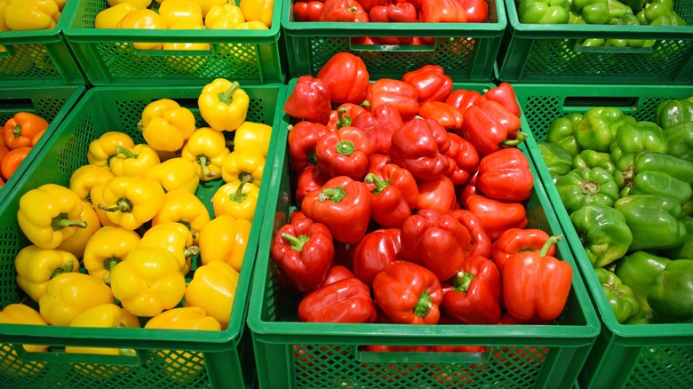 Baskets of yellow, red, and green bell peppers separated by color