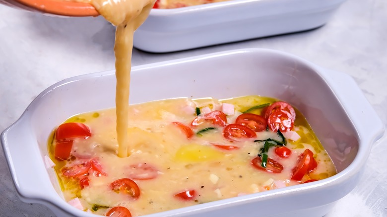 Egg mixture pouring into casserole dish